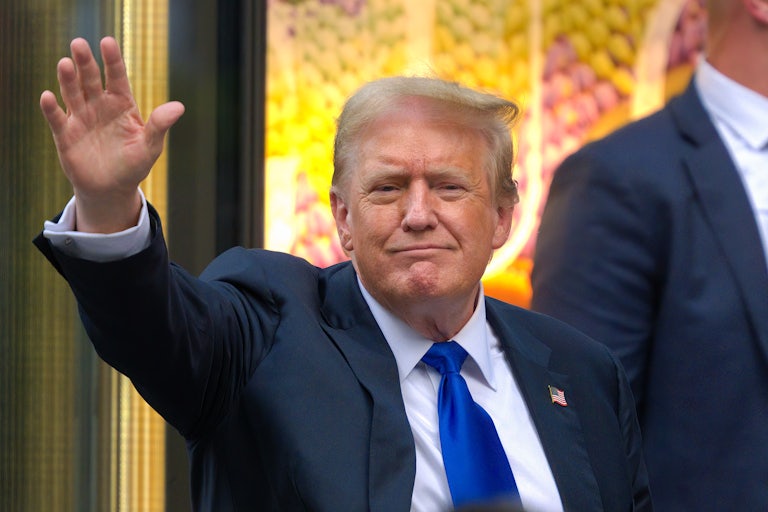 Donald Trump smiles and waves