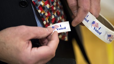 A person holds "I voted" stickers