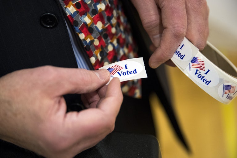 A person holds "I voted" stickers
