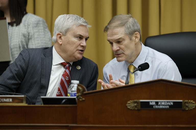 James Comer and Jim Jordan talk while seated at the dais