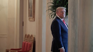 Donald Trump smiles as he walks into a doorway