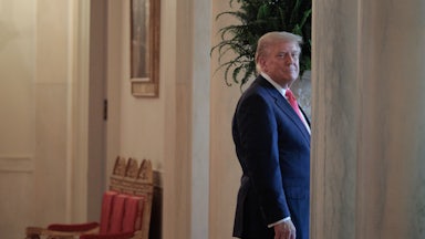 Donald Trump smiles as he walks into a doorway