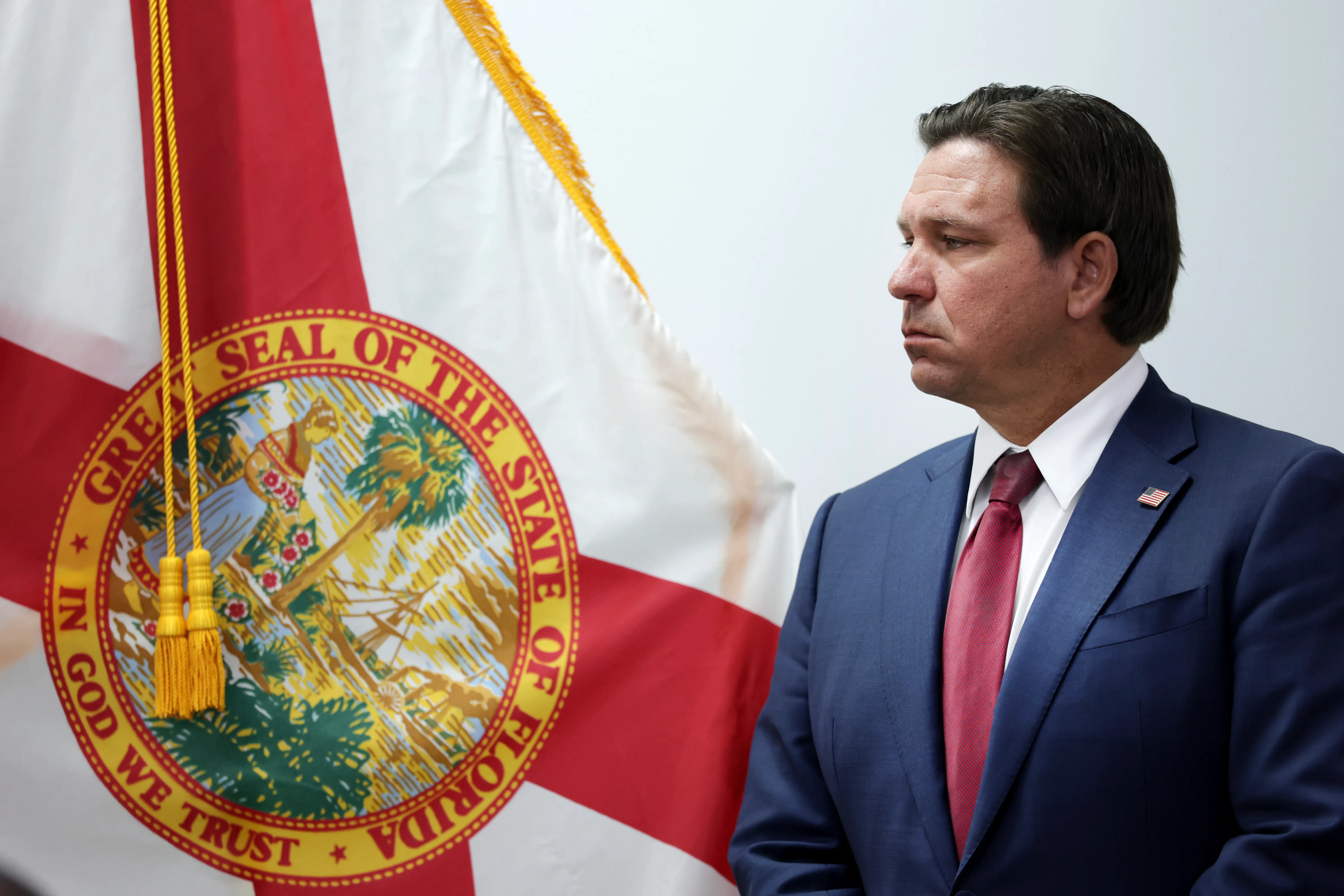 Ron DeSantis stands in front of the Florida state flag