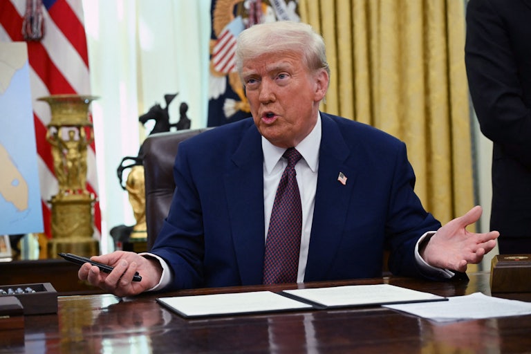 Donald Trump gestures while speaking to reporters in the Oval Office