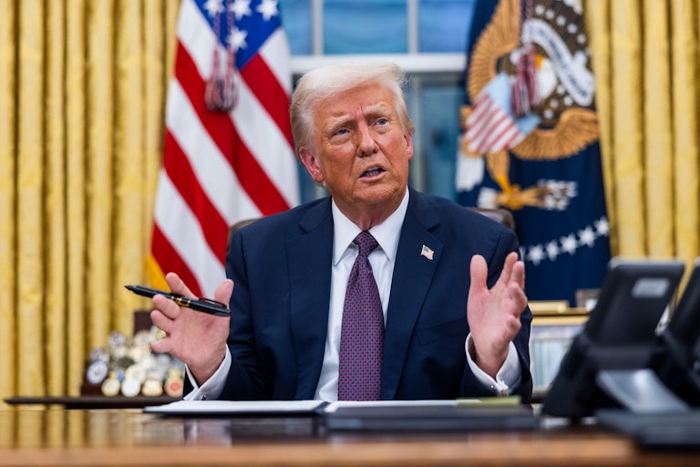 Donald Trump looks confused as he prepares to signs something in the Oval Office