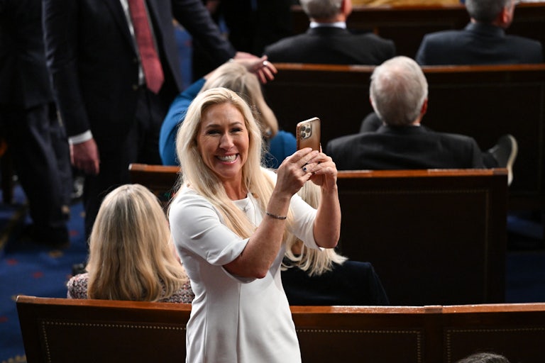 Marjorie Taylor Greene holds up her phone on the House floor.