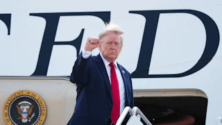 Donald Trump raises his fist while boarding Air Force One