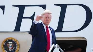 Donald Trump raises his fist while boarding Air Force One