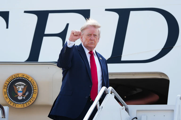 Donald Trump raises his fist while boarding Air Force One