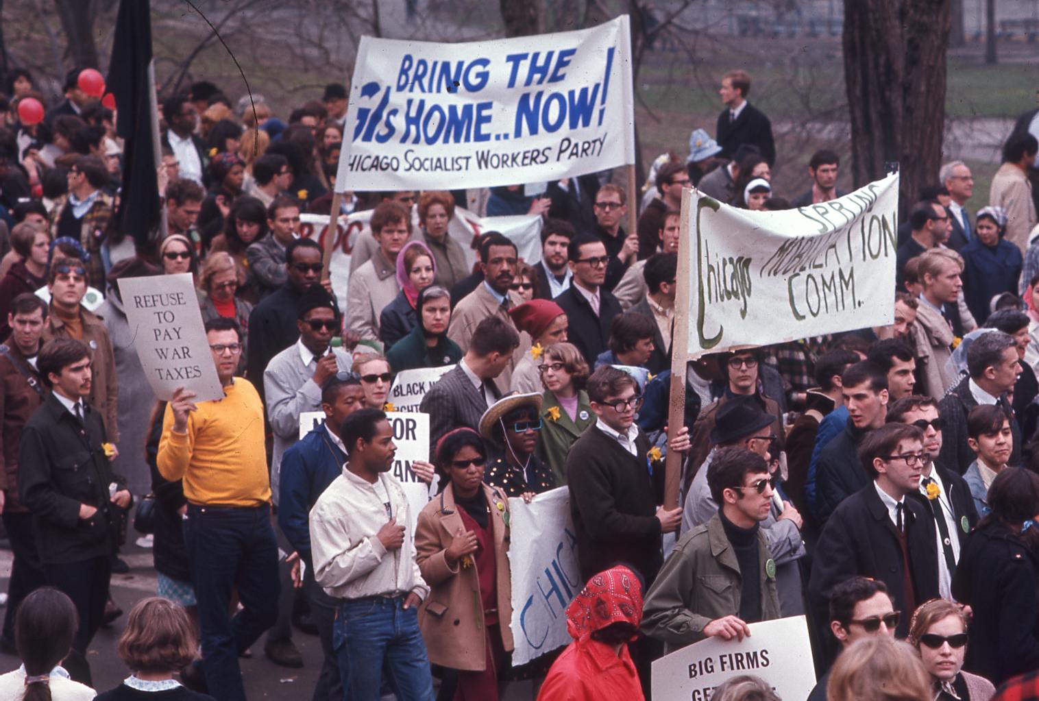 Anti-war protesters assemble with banners reading "Bring Them Home Now!" 