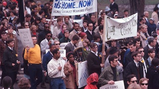 Anti-war protesters assemble with banners reading "Bring Them Home Now!"