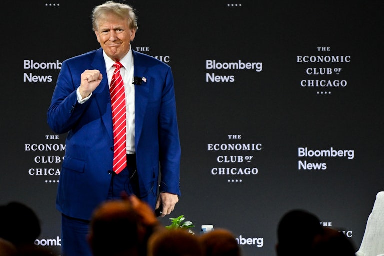 Donald Trump raises his fist before an interview at the Economic Club of Chicago