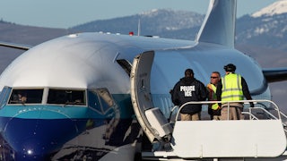 U.S. Immigration and Customs Enforcement agents prepare to board a charter flight in Yakima, Washington.