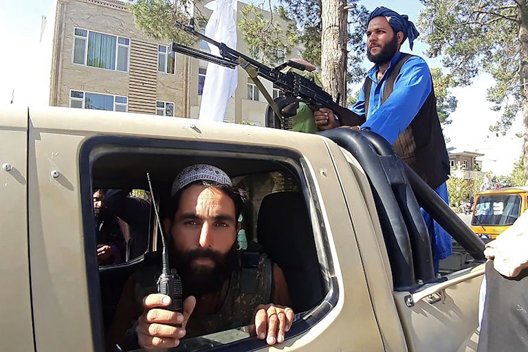 Taliban fighters are pictured in a vehicle along the roadside in Herat, Afghanistan.