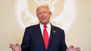 Donald Trump speaks in front of a presidential seal silhouette.