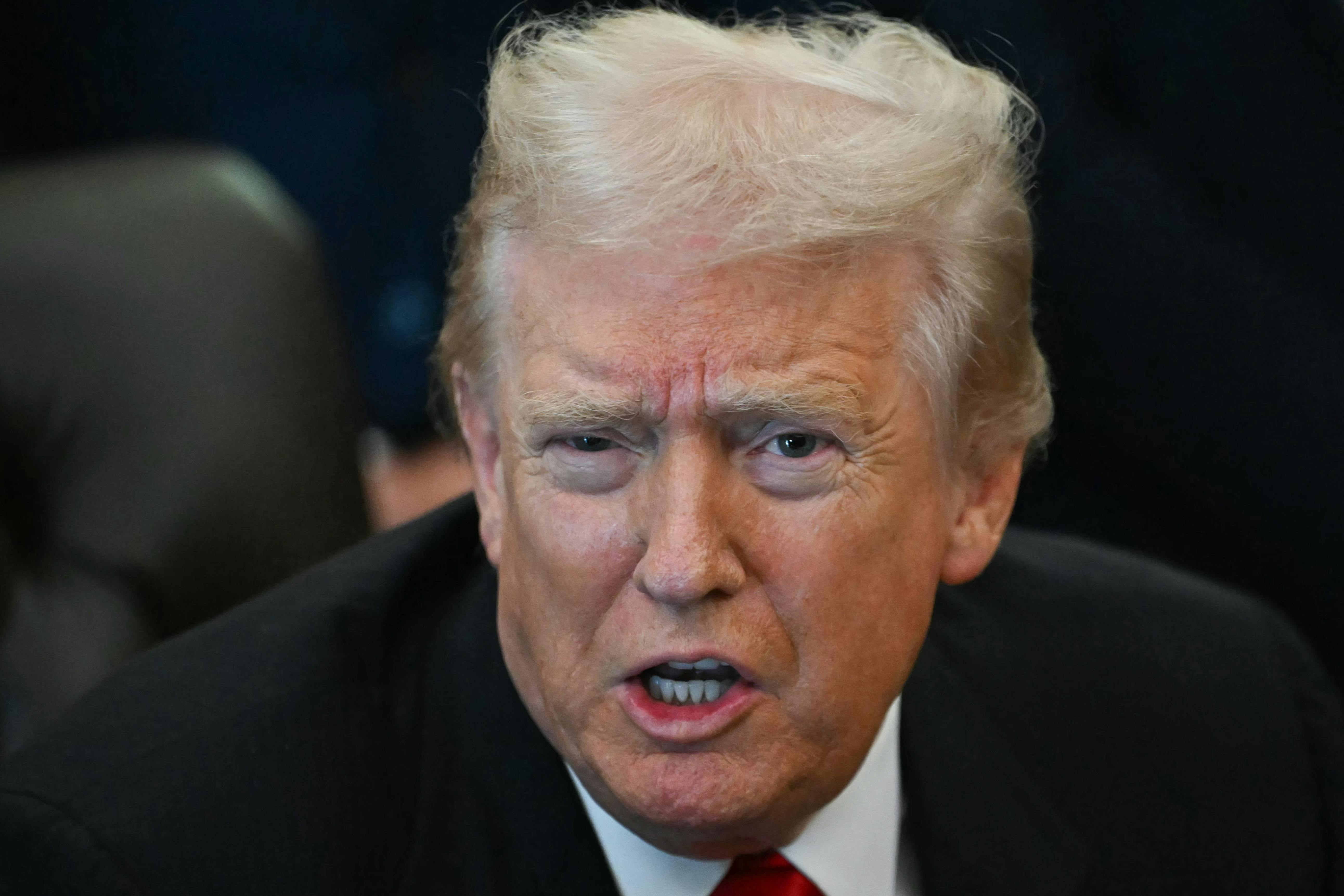 Donald Trump speaks while sitting at his desk in the Oval Office