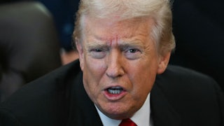 Donald Trump speaks while sitting at his desk in the Oval Office