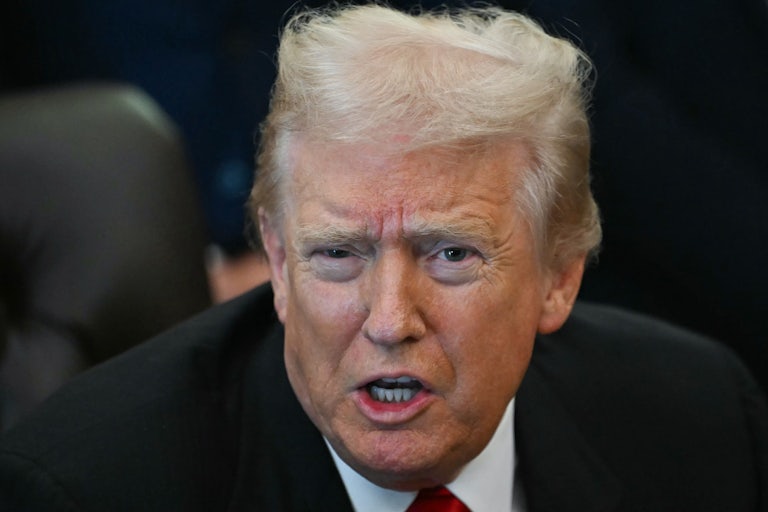 Donald Trump speaks while sitting at his desk in the Oval Office