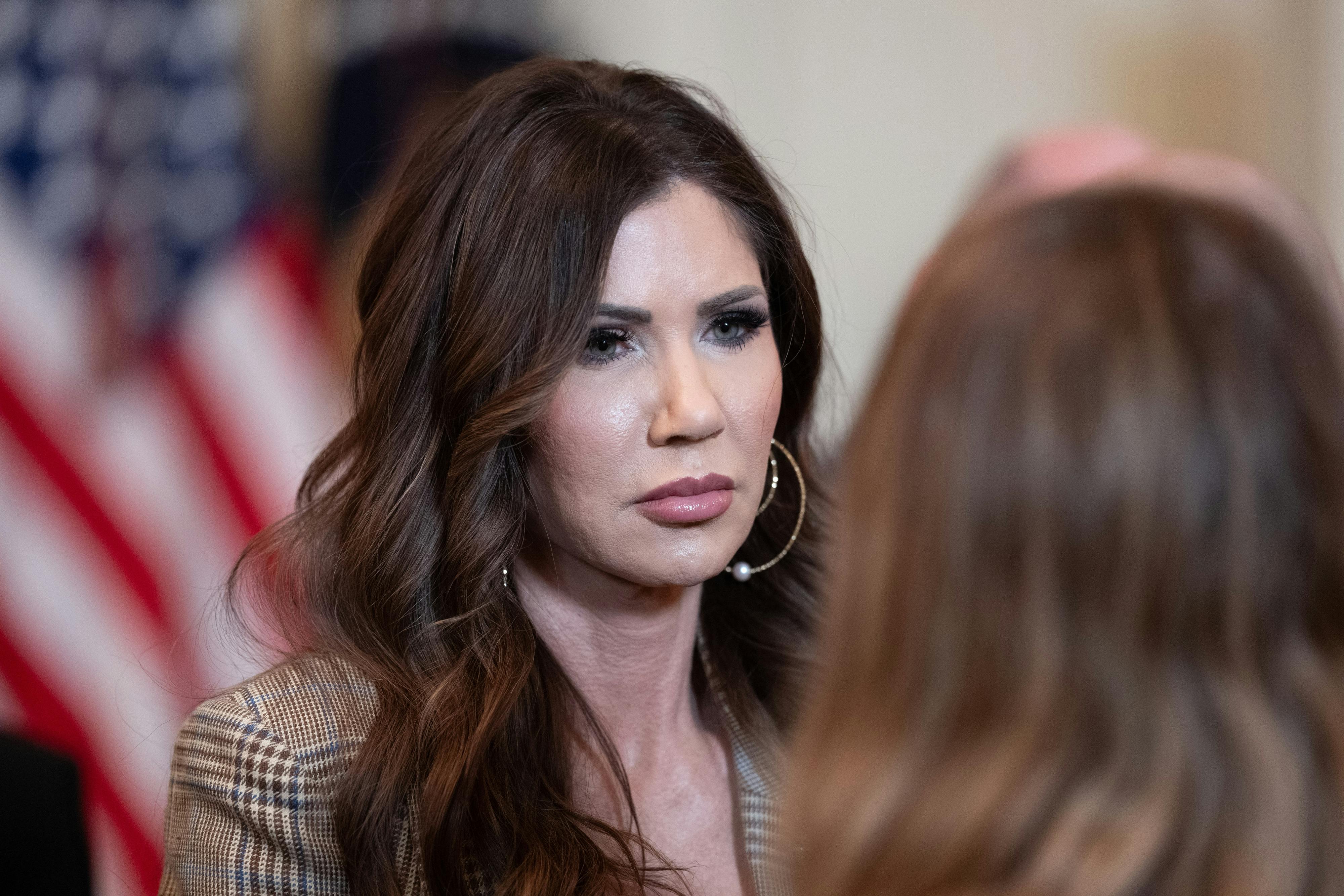 Homeland Security Secretary Kristi Noem stands during an event