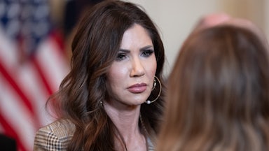 Homeland Security Secretary Kristi Noem stands during an event