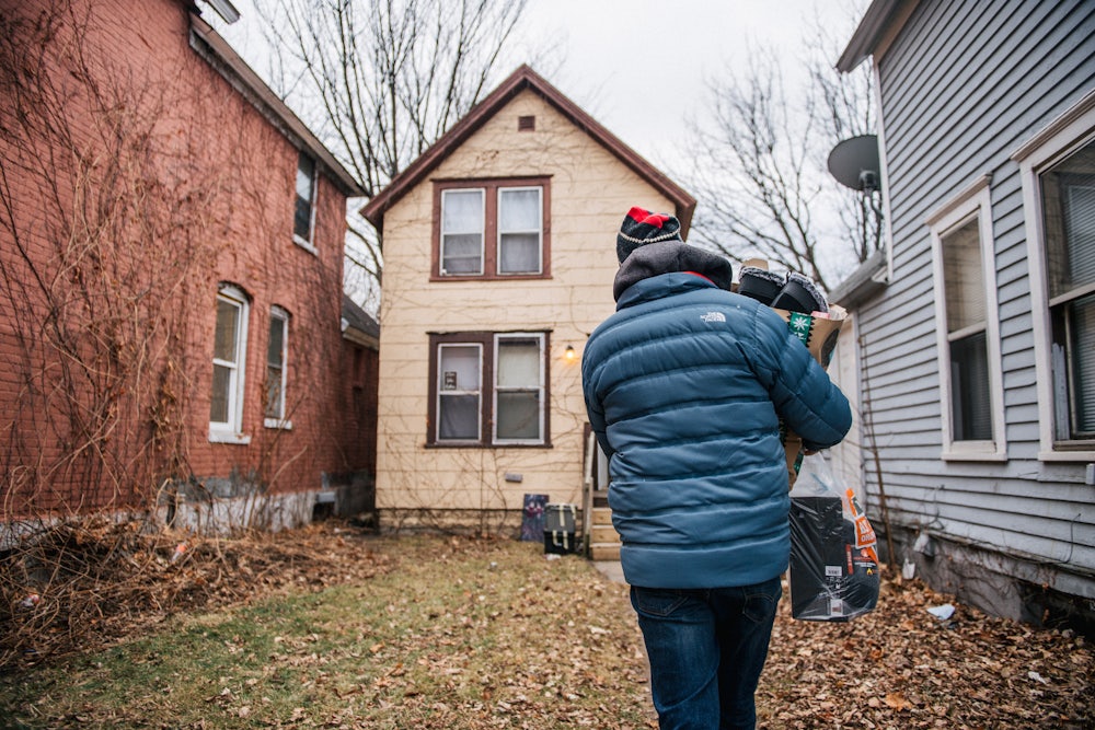 a man carries a bag of gifts to a home in St. Paul, Minnesota.
