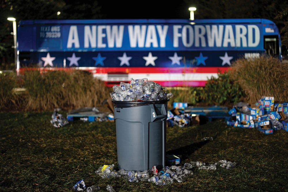 A garbage can filled with trash in front of a Kamala Harris campaign bus on the night of the election