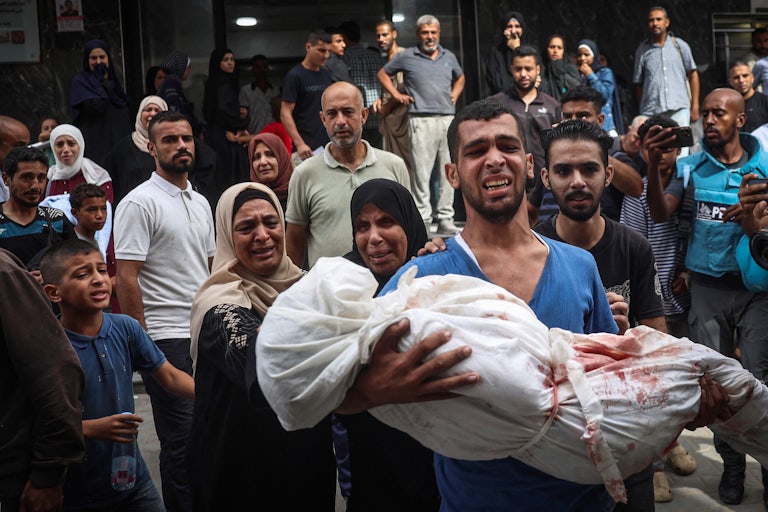 A Palestinian man carries the body of a relative killed at the Bureij refugee camp, in the central Gaza Strip on September 17, 2024,.