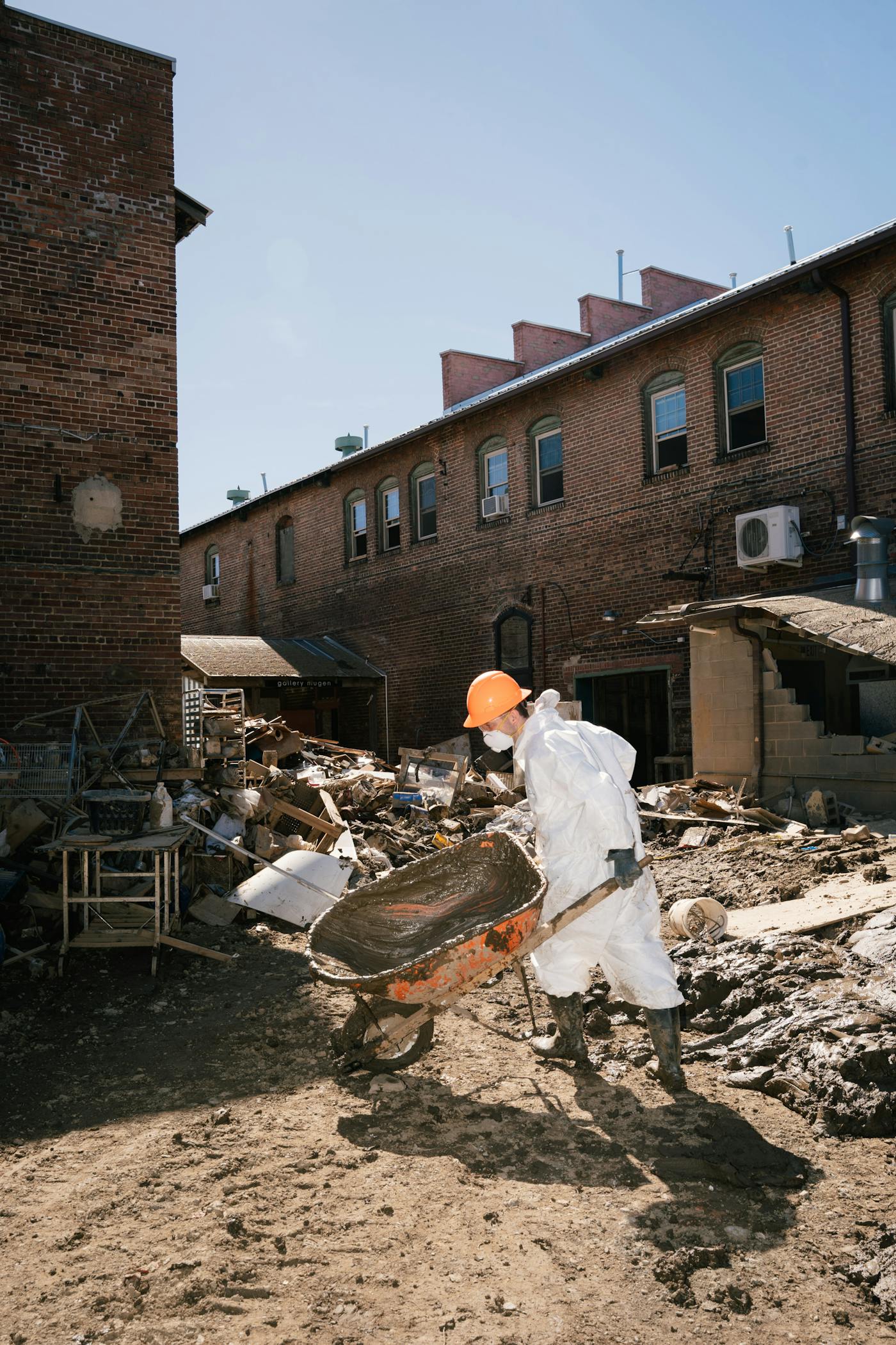 A photograph of Sam Sharp, an employee of the Southern Appalachian Wilderness Stewards, wearing protective gear to shield himself from mud. Environmental organization MountainTrue tested around the French Broad River watershed and released a partial report indicating the mud may contain organic and chemical pollutants. Cleanup crews in the area wore personal protective equipment.