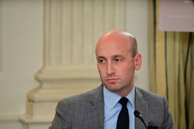 Stephen Miller sits in front of a microphone during an event at the White House