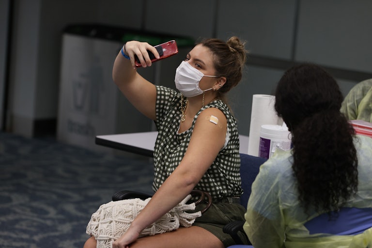 A woman takes a selfie after receiving a Covid shot.