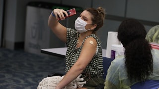 A woman takes a selfie after receiving a Covid shot.