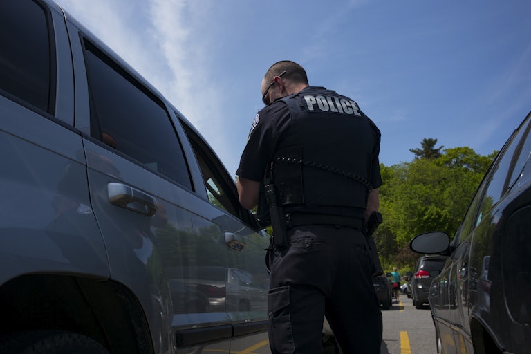 A police officer stands next to a car