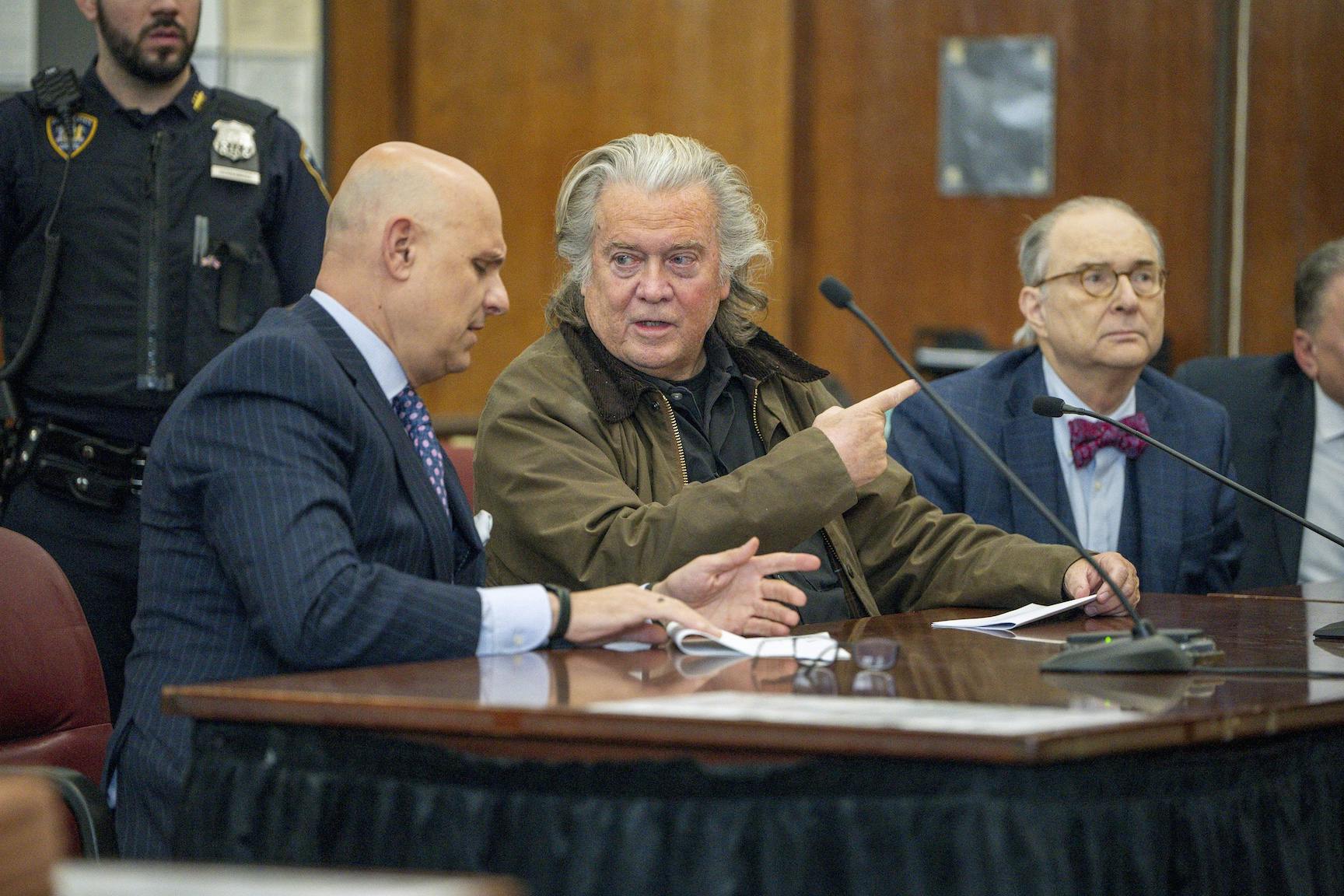 Steve Bannon speaks to his attorney in court.
