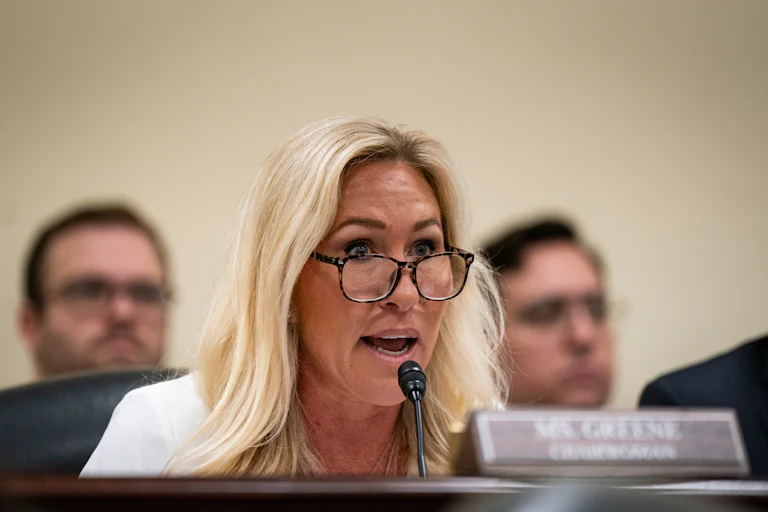 Former Representative Marjorie Taylor Greene speaks into a microphone during a House subcommittee hearing