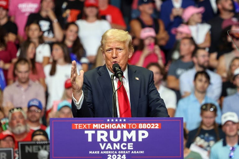 Donald Trump gestures while speaking at a podium during a campaign rally