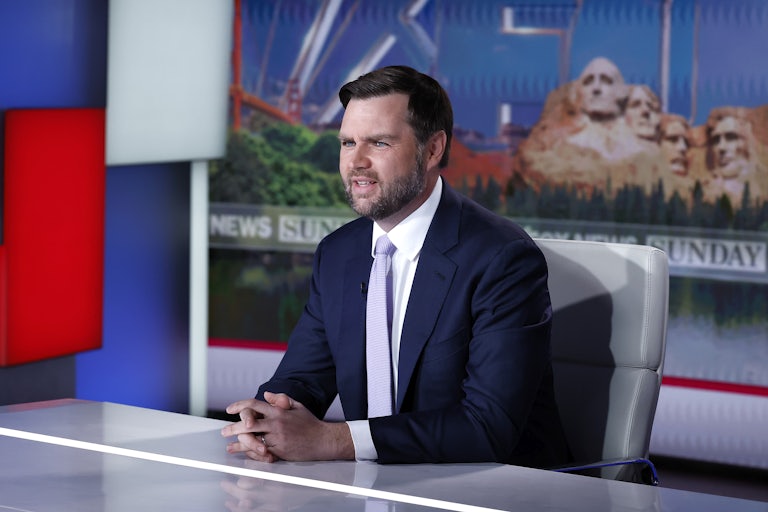 JD Vance sits at a desk with his hands folded