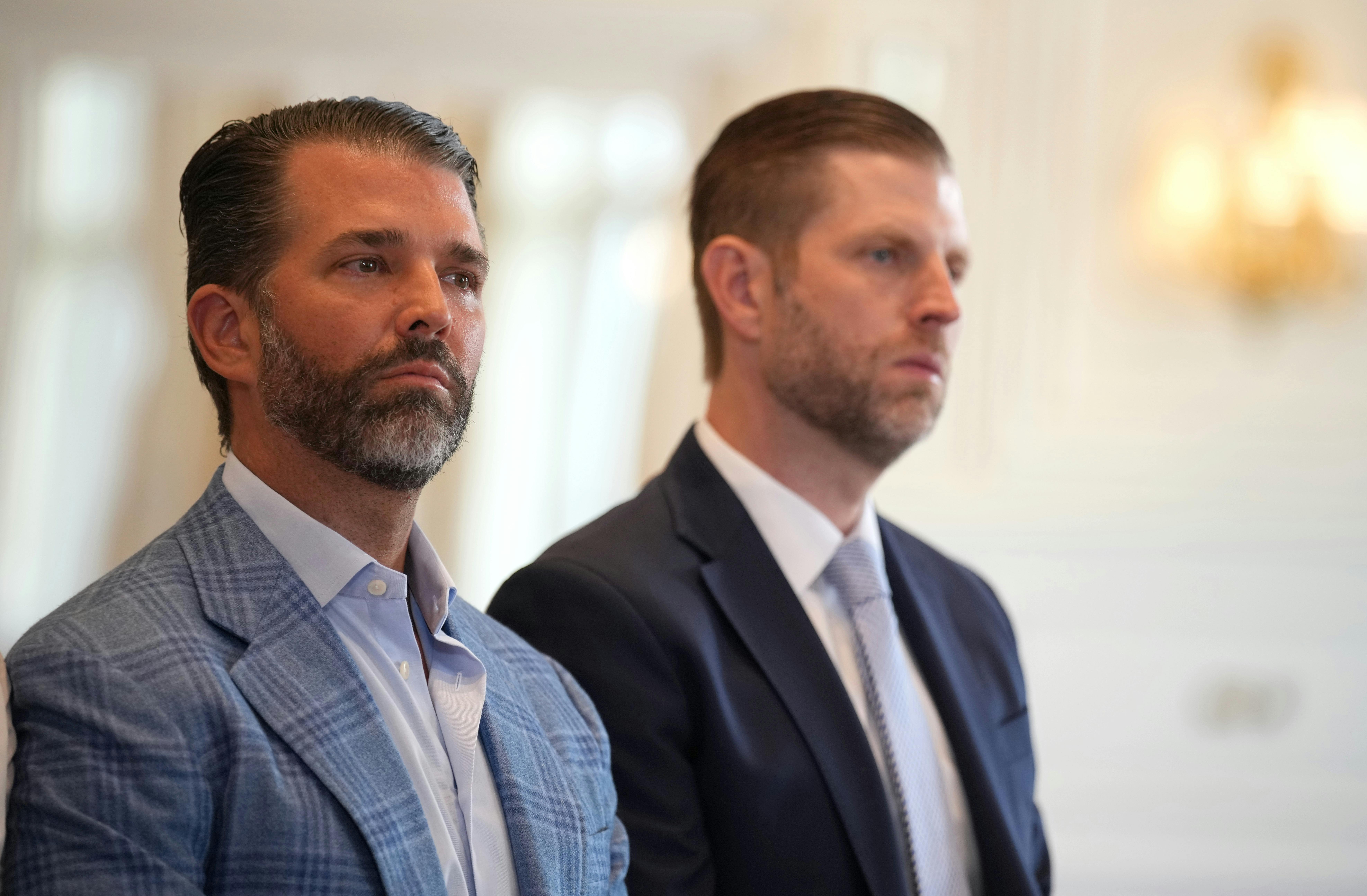 Donald Trump Jr. and Eric Trump stand next to each other