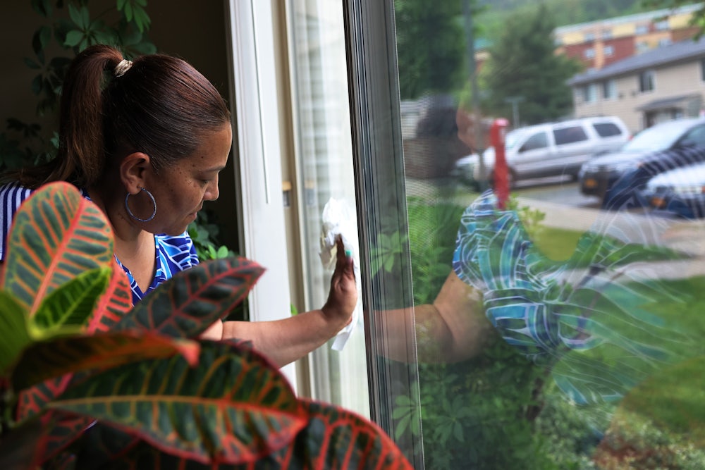 Home health aide cleans window