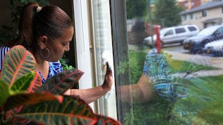 Home health aide cleans window