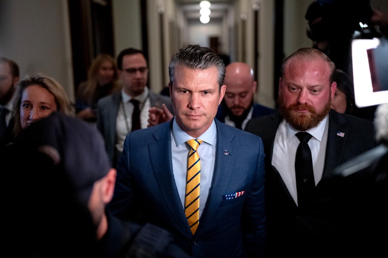 Pete Hegseth surrounded by press walks through the Capitol