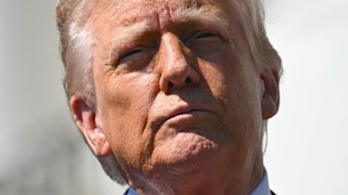 Donald Trump squints into the sun, facing the camera.