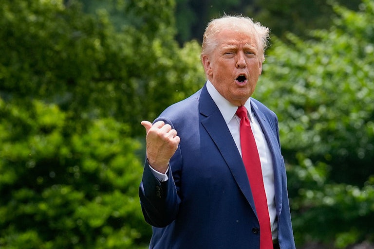 Donald Trump yells and points behind him while on the White House lawn.