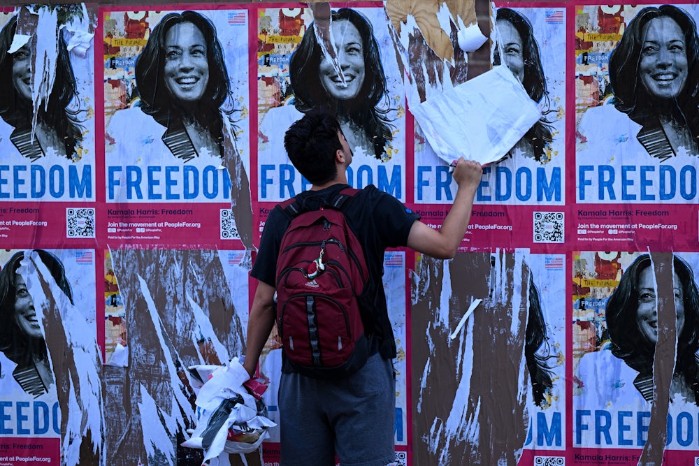 A demonstrator tears down posters of Kamala Harris