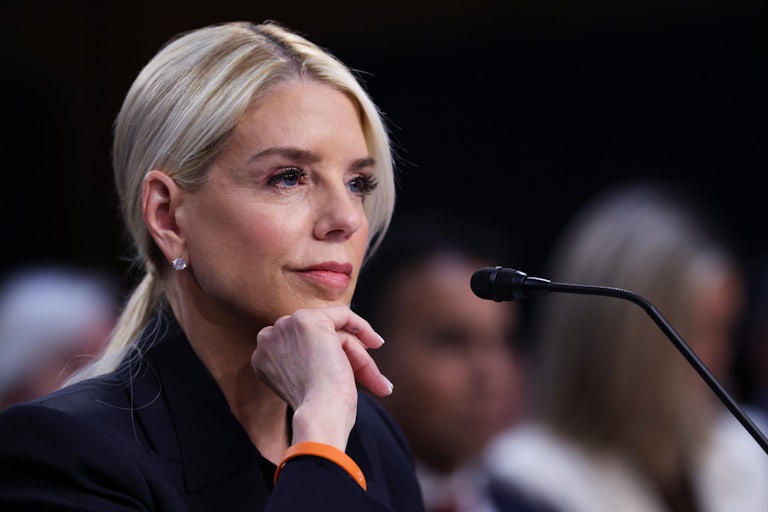Pam Bondi smiles with her hand on her chin, as she appears in the Senate to testify.