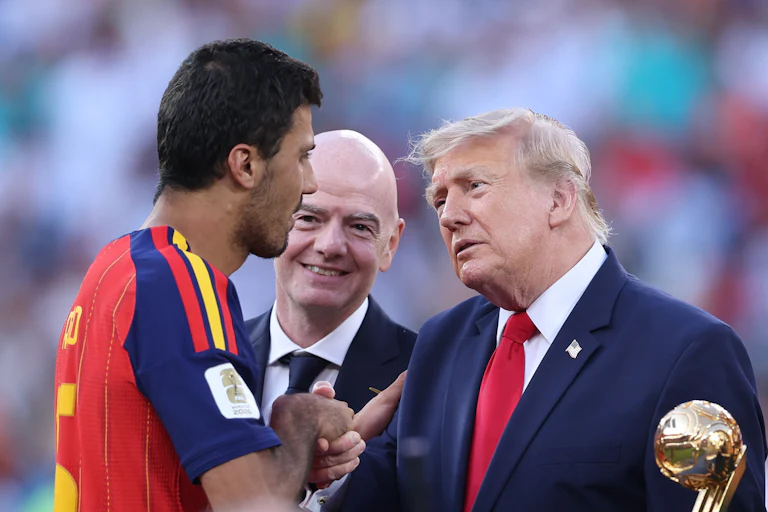 Donald Trump, standing next to FIFA President Gianni Infantino, shakes hands with Spanish player Rodrigo Hernández Cascante after the World Cup.