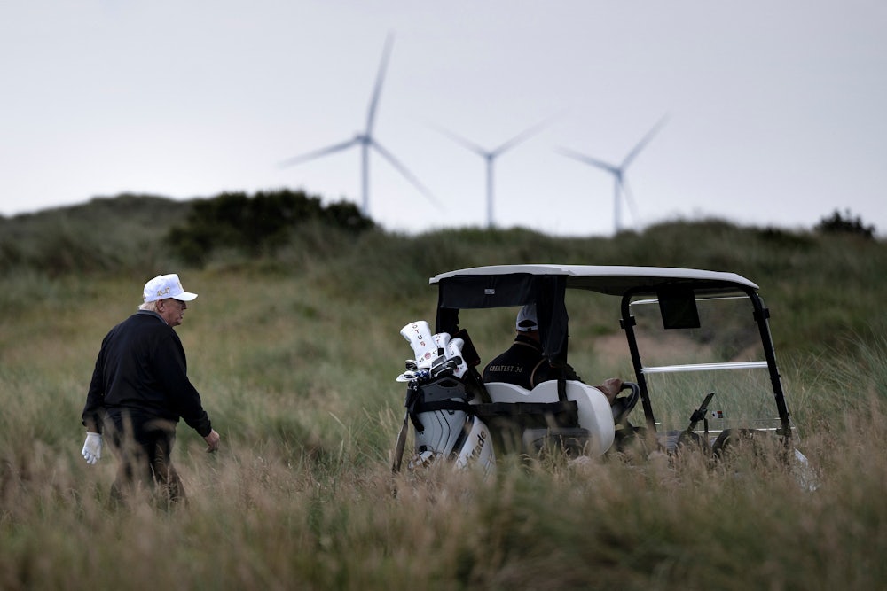 Trump playing golf with wind farm in background