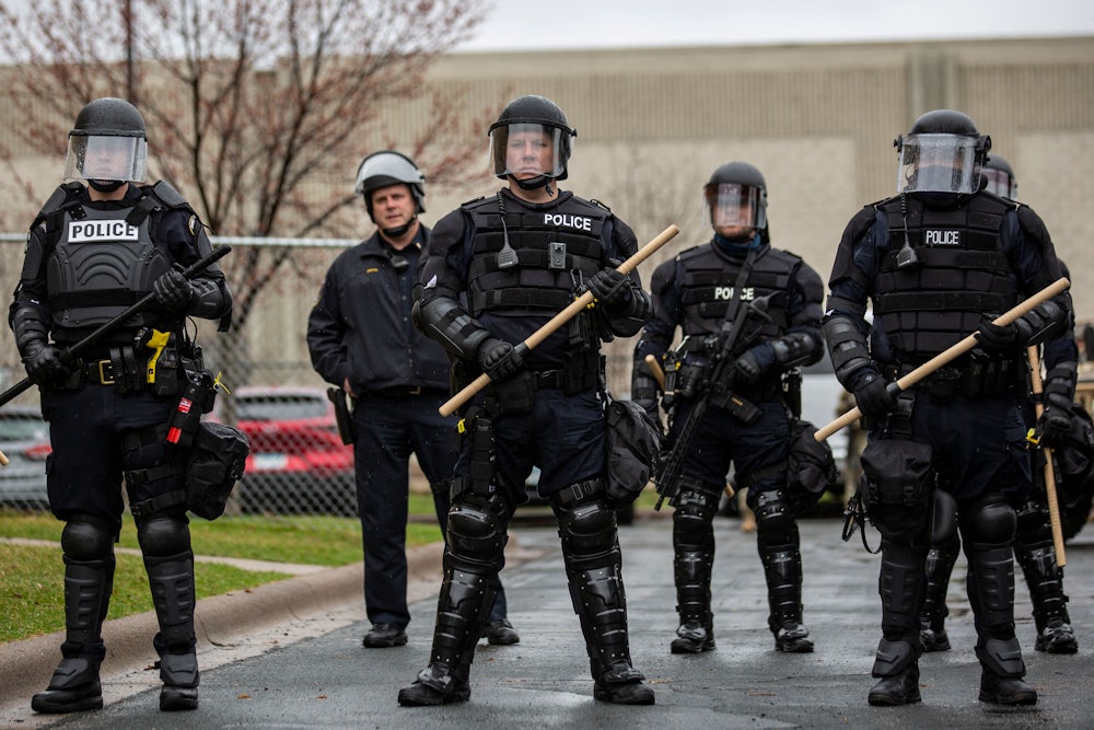 Police officers stand guard outside the Brooklyn Center police station after a police officer killed a Black man in Minneapolis.