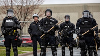 Police officers stand guard outside the Brooklyn Center police station after a police officer killed a Black man in Minneapolis.