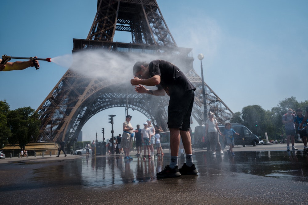 A municipal employee in Paris sprays water to cool off tourists in front of the Eiffel Tower on July 2.