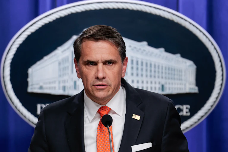 Acting Attorney General Todd Blanche frowns and speaks during a press conference